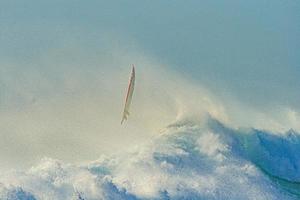 imagem de prancha de surf voando depois de cair sobre onda alta foto