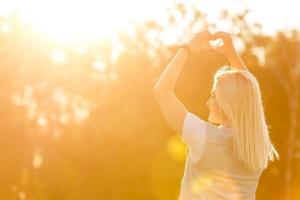 mulher feliz livre curtindo a natureza. menina de beleza ao ar livre. conceito de liberdade. menina de beleza sobre o céu e o sol. raios de sol. prazer foto