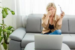 trabalho durante a quarentena, uma mulher em casa trabalha no laptop foto