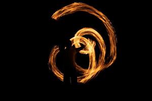 uma bela foto de uma pessoa fazendo um show de poi de fogo no escuro