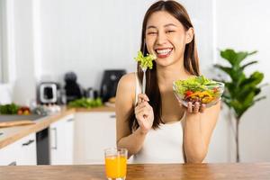 feliz mulher asiática e tailandesa comendo salada e vegetais, dieta e conceito vegetariano