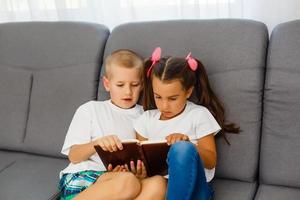 as crianças lêem um livro em casa foto