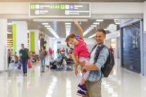 papai está abraçando a garota no saguão do aeroporto com felicidade. foto