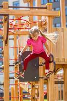 menina atraente em equipamentos de playground ao ar livre foto