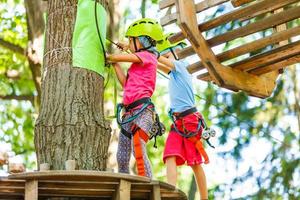 parque de escalada de aventura - parque de corda para crianças no curso de capacete de montanha e equipamento de segurança foto