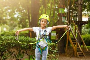 menina feliz em um parque de corda no fundo de madeira foto