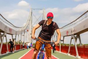 homem parado em uma ponte com bicicleta foto