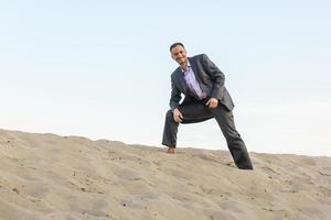 homem bonito elegantemente vestido andando no deserto foto