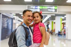 menina com seu pai informações de voo de fundo no aeroporto foto