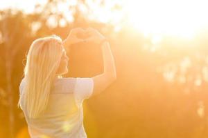 mulher jovem e atraente aproveitando seu tempo lá fora no parque com o pôr do sol no fundo. foto