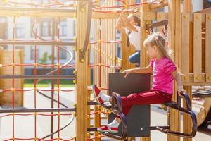 menina atraente em equipamentos de playground ao ar livre foto