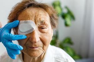 médico verificando os olhos do paciente da velha senhora sênior ou idosa no hospital. cuidados de saúde e conceito médico. foto