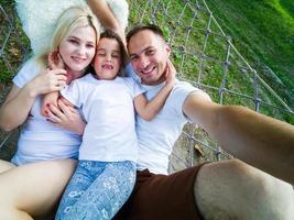 família relaxando na rede do jardim juntos foto