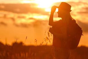 menina turista feliz com mochila e chapéu foto