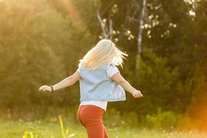 mulher feliz livre curtindo a natureza. menina de beleza ao ar livre. conceito de liberdade. menina de beleza sobre o céu e o sol. raios de sol. prazer foto