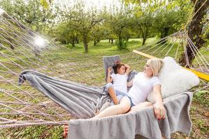 mãe e filha dormindo juntas na rede do jardim foto