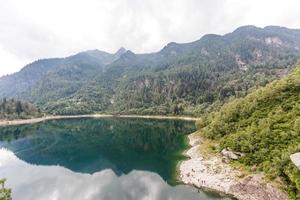 lago alpino de alta montanha, madeiras de coníferas são refletidas na água, vale antrona lago campliccioli, itália piemonte foto