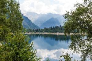 lago alpino de alta montanha, madeiras de coníferas são refletidas na água, vale antrona lago campliccioli, itália piemonte foto