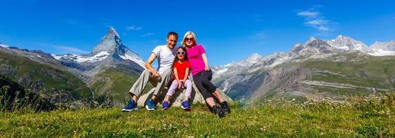 família em um dia de caminhada na montanha olhando a vista foto