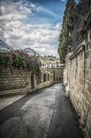 uma estrada estreita descendo o monte das oliveiras até a cidade de jerusalém foto