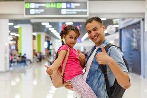 papai está abraçando a garota no saguão do aeroporto com felicidade. foto