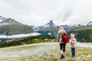 mulher e menina alpinista feliz no lago de montanhas foto