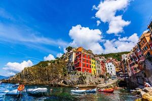 cinque terre, itália 18 de julho de 2019 visão clássica de manarola - casas coloridas em uma dramática formação rochosa perto do mar com um porto natural de pesca foto