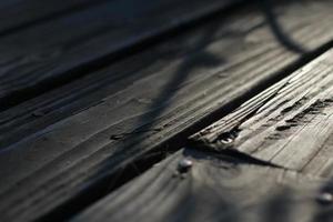 varanda de madeira com luz solar nas costas pela manhã, fundo fora do campo, textura de madeira, varanda de madeira marrom. foto