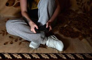 uma jovem joga videogame com um joystick preto com muitos b foto