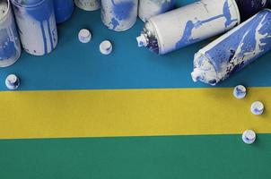 bandeira de ruanda e algumas latas de spray aerossol usadas para pintura de grafite. conceito de cultura de arte de rua foto