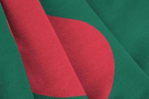 bandeira de bangladesh com grandes dobras acenando perto sob a luz do estúdio dentro de casa. os símbolos e cores oficiais no banner foto