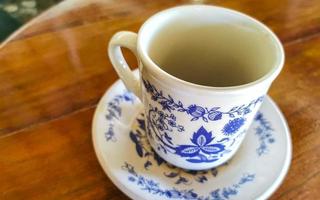 pote de xícara branca azul com mesa de madeira de café preto méxico. foto