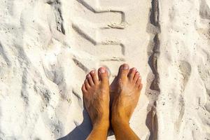 sulcos de escavadeira e pés na areia da praia México. foto
