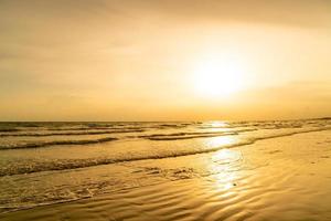 bela praia do mar com hora do pôr do sol foto