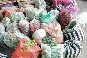 mercado tradicional, legumes frescos em plástico prontos para serem vendidos na comunidade foto