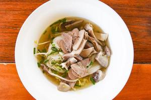 tigela de macarrão delicioso close-up de sopa de macarrão aletria com ensopado de carne de porco e legumes na tigela comida tradicional tailandesa e chinesa da ásia, miudezas de porco, intestinos de porco fígado foto