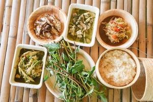 comida asiática, comida de rua tailândia na vista superior do fundo de madeira - conceito de utensílios de mesa descartáveis ecológicos foto