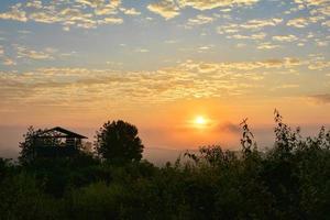 nevoeiro nascer do sol durante o inverno bela manhã com cobertura enevoada no prado foto