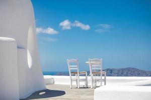 mesa romântica montada em santorini, grécia. arquitetura branca e mesa para dois. conceito de amor no destino de viagem romântica, férias de verão ou conceito de férias. foto