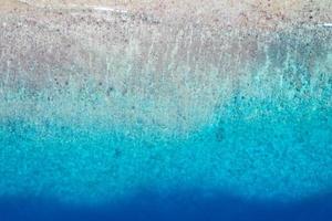 vista aérea do mar, vista superior do incrível fundo do oceano natural. cores de água azul brilhante, praia de lagoa com ondas espirrando no dia ensolarado. foto de drone voador, incrível paisagem natural com recifes de corais