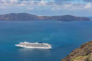 10.05.19 ilha de santorini, grécia bela paisagem com navios de cruzeiro e vista para o mar, fundo do vulcão. viagens de verão de luxo e fundo turístico. navio de cruzeiro gigante foto