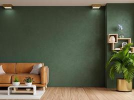 sala de estar com sofá de couro e acessórios no fundo da parede verde escura vazia. foto