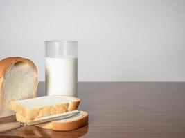 fatia de pão com faca com copo de leite no espaço de cópia de mesa foto