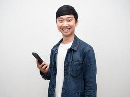 homem alegre camisa jeans sorriso segurando smartphone foto