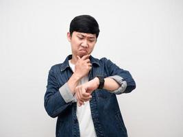 homem asiático camisa jeans emoção séria olhando para o relógio isolado foto