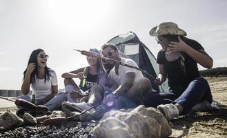 verão, feriados, férias, música, conceito de pessoas felizes - grupo de amigos com guitarra se divertindo na praia foto