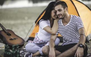 conceito de férias de piquenique. lindo casal se divertindo fazendo churrasco na fogueira e relaxando em um lago. foto