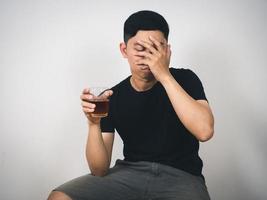 homem asiático alcoolismo sentado parece sem esperança foto