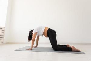 mulher grávida proposital se exercita durante a aula de ioga e relaxa enquanto está sentada em um tapete no chão. conceito de preparação física e mental do corpo para o parto. lugar para texto foto