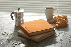natureza morta para uma agradável xícara turca de café da manhã e croissants com dois livros sobre a mesa. conceito de pausa para o almoço ou comece a manhã foto